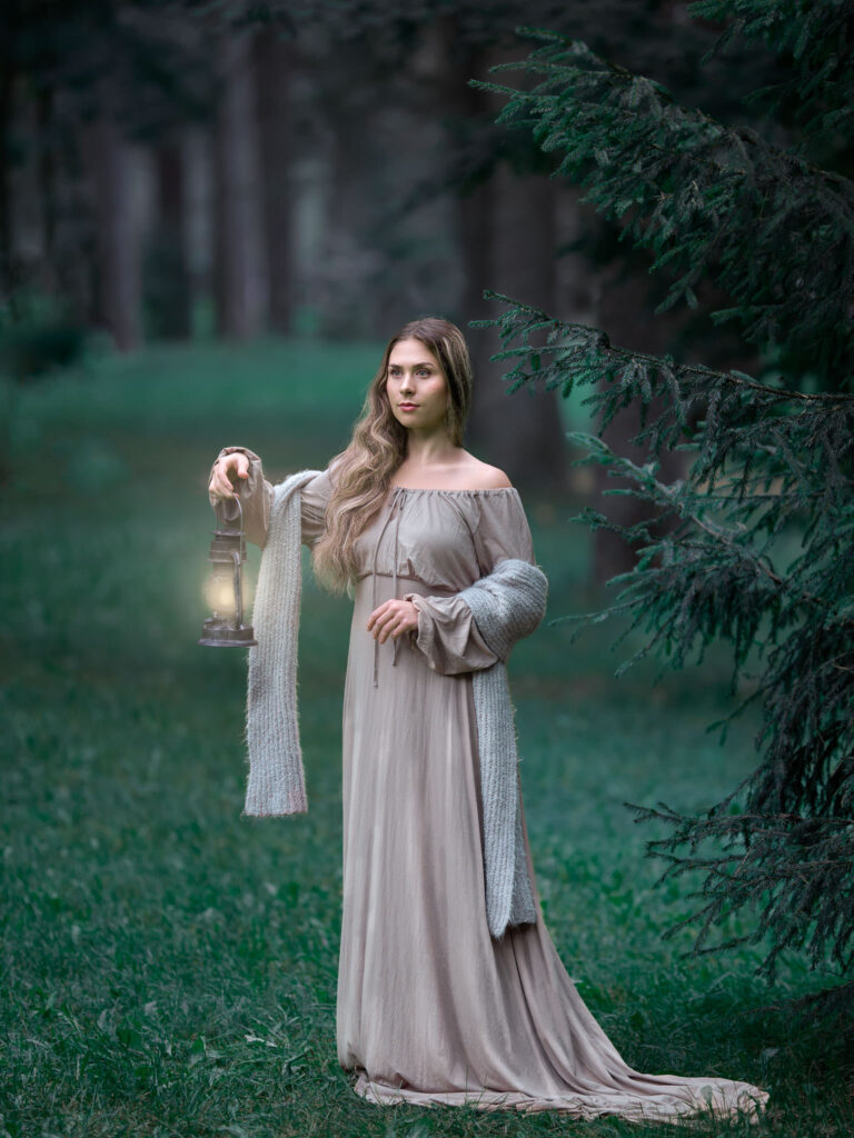 ung kvinna i beige långklänning står i en trolsk granskog och håller en lykta i handen